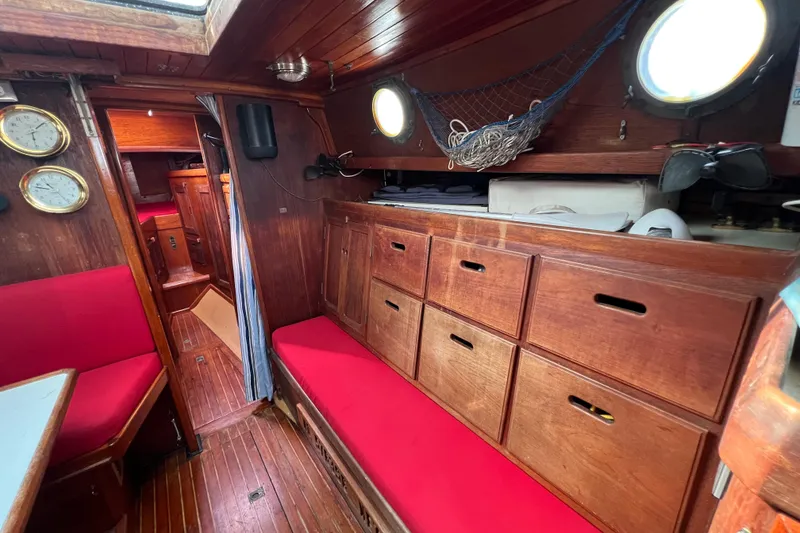 Slide: The Image of Interior of 1976 Westsail 32 sailboat with red seating and wooden flooring. - 51