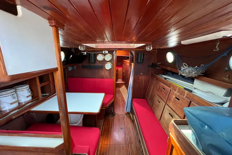 Slide: The Image of Interior of 1976 Westsail 32 sailboat with red cushions and wooden cabinetry. - 52