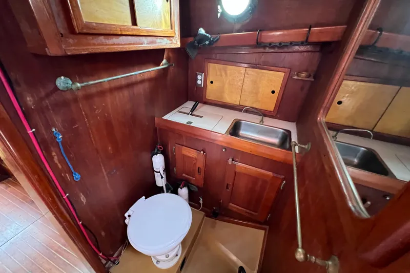 Slide: The Image of 1976 Westsail 32 cabin interior with red cushions and wooden cabinetry. - 53