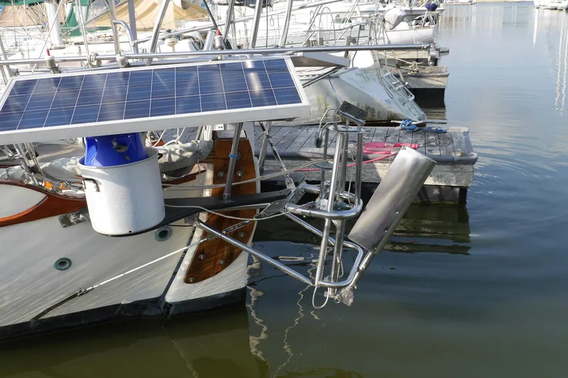 Slide: The Image of 1976 Westsail 32 sailboat with covered boom, docked under a clear blue sky. - 8
