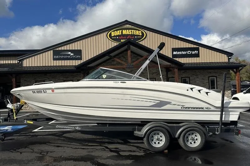 The Image of 2022 Chaparral 23 SSi boat on trailer at dealership, cloudy sky background. - 1