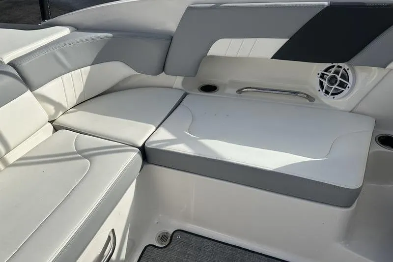 Slide: The Image of 2022 Chaparral 23 SSi boat interior with white and gray seating, speaker, and cup holder. - 13