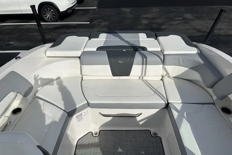 Slide: The Image of 2022 Chaparral 23 SSi boat interior with white cushioned seating and sleek design. - 14