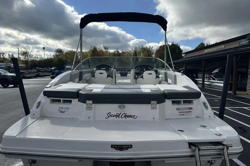 Slide: The Image of 2022 Chaparral 23 SSi boat with seating, docked under cloudy sky. - 2