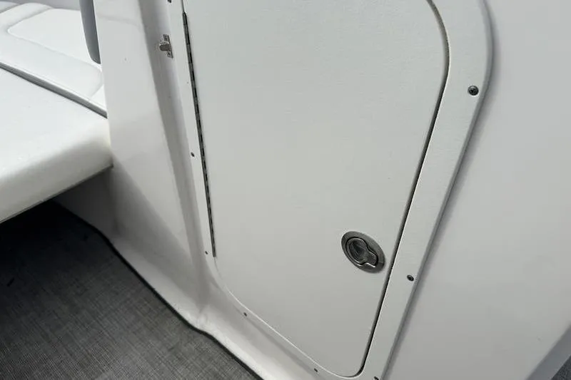 Slide: The Image of 2022 Chaparral 23 SSi boat storage compartment with sleek white finish. - 28