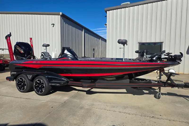 The Image of 2022 Skeeter FXR20 Apex boat with red and black design, parked outside a building. - 0