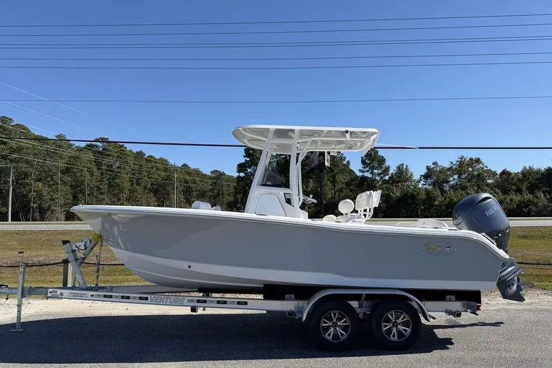 The Image of 2026 Sea Hunt Ultra 219 boat on trailer, side view, clear sky background. - 1