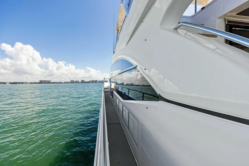 Slide: The Image of Side view of a 2018 Princess Y75 yacht cruising on calm waters under a clear sky. - 54