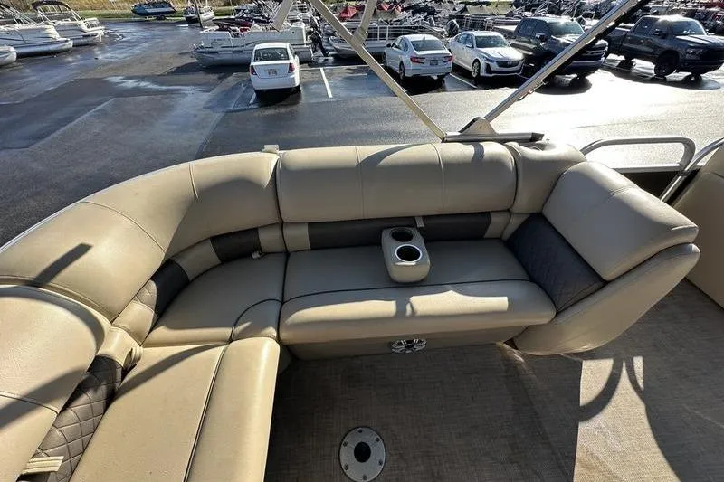 Slide: The Image of 2023 Sun Tracker Party Barge 20 DLX with beige seating and cup holders in a parking lot. - 25