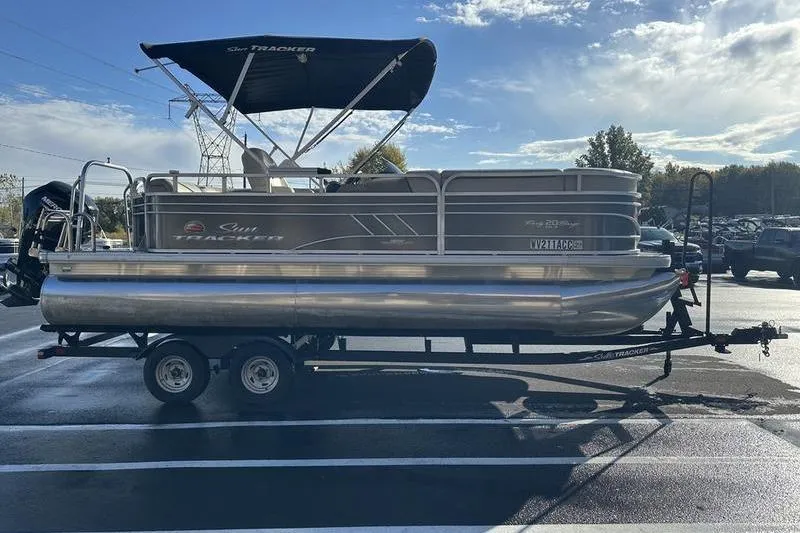 Slide: The Image of 2023 Sun Tracker Party Barge 20 DLX pontoon boat on trailer, parked outdoors. - 7