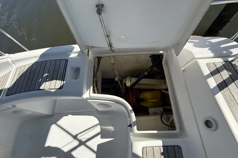 Slide: The Image of Open hatch on 2005 Beneteau Oceanis 373 sailboat, revealing storage compartment and equipment. - 19