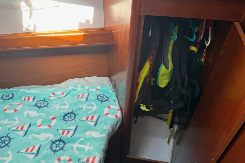 Slide: The Image of Cozy cabin interior of 2005 Beneteau Oceanis 373 with nautical-themed blanket and life jackets. - 50