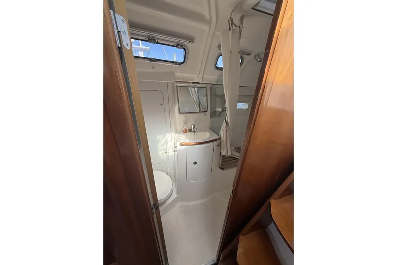 Slide: The Image of 2005 Beneteau Oceanis 373 yacht bathroom with sink, toilet, and shower. - 52