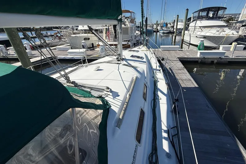 Slide: The Image of 2005 Beneteau Oceanis 373 sailboat docked at marina, featuring green canopy. - 8