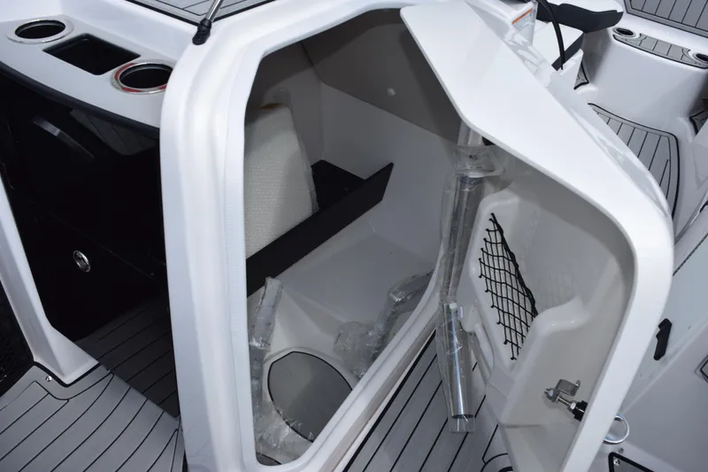 Slide: The Image of 2026 Yamaha Boats 252S interior storage compartment with cup holders and netting. - 20