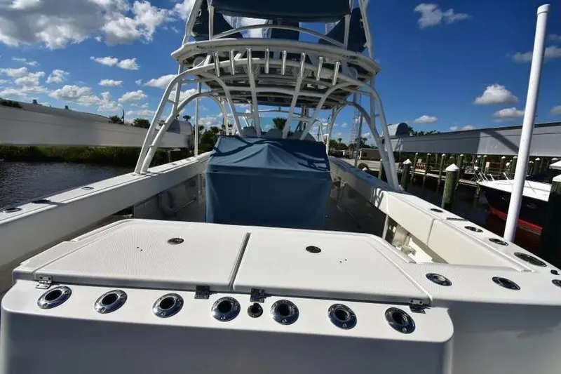 Slide: The Image of 2012 Hydra-Sports 4200 Siesta boat with fishing rod holders, docked under a blue sky. - 12