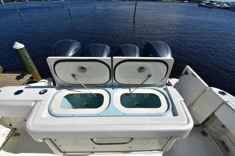 Slide: The Image of 2012 Hydra-Sports 4200 Siesta boat with open livewell compartments, docked by the water. - 22