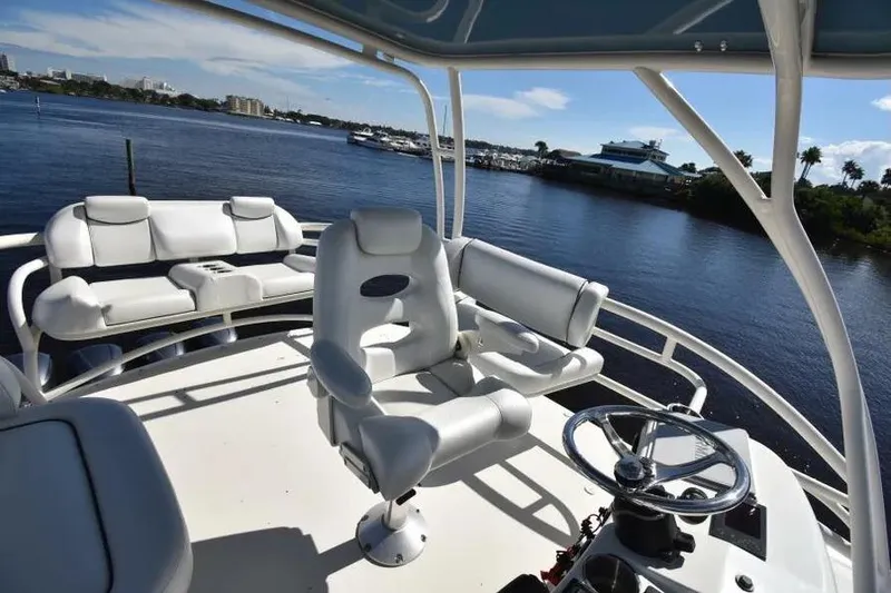 Slide: The Image of 2012 Hydra-Sports 4200 Siesta boat interior with white seating and steering wheel, dockside view. - 9