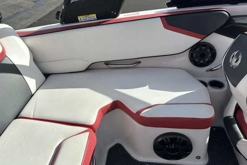 Slide: The Image of 2016 Scarab 195 H.O. boat interior with white and red seating, speakers, and cup holders. - 11