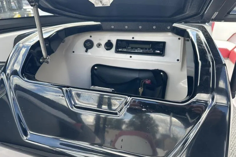 Slide: The Image of Open storage compartment in 2016 Scarab 195 H.O. boat with control panel and accessories. - 20