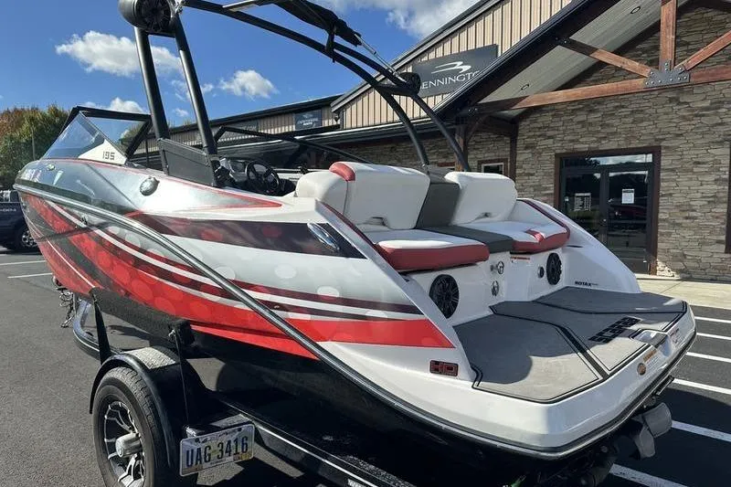 Slide: The Image of 2016 Scarab 195 H.O. boat with red and white design, parked outdoors. - 3