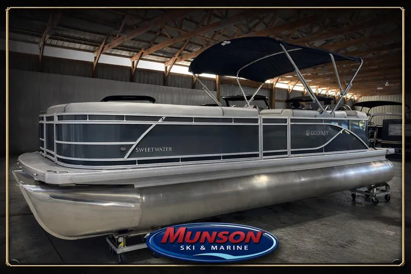 The Image of 2026 Godfrey SW 2286 CSE pontoon boat in showroom, featuring sleek design and canopy. - 0