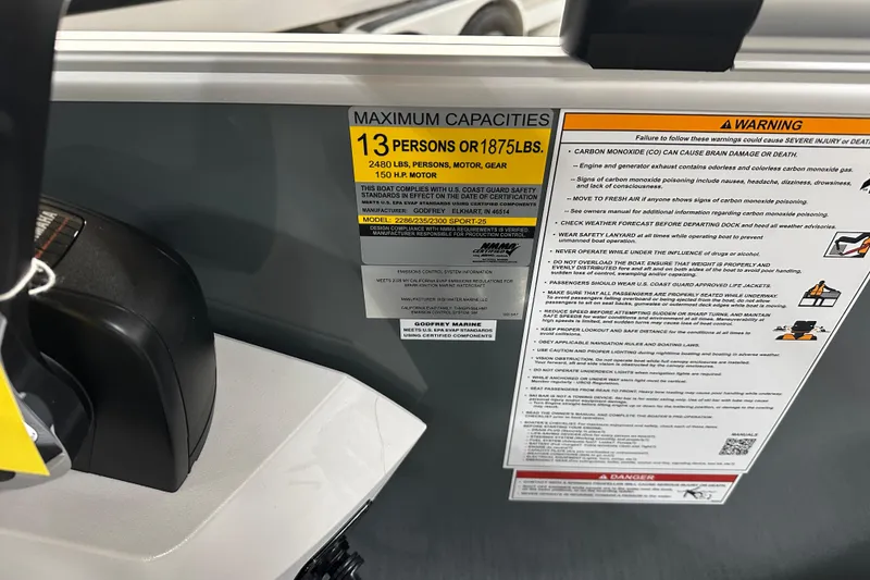 Slide: The Image of 2026 Godfrey Sweetwater 2286 C capacity and safety warning labels on boat interior. - 14