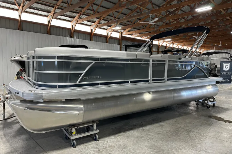 Slide: The Image of 2026 Godfrey Sweetwater 2286 C pontoon boat in a warehouse setting. - 18