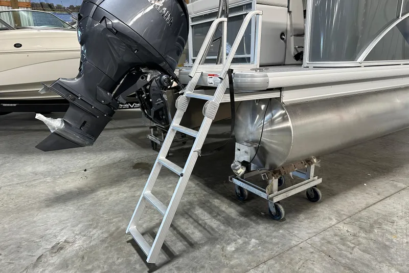 Slide: The Image of 2026 Godfrey Sweetwater 2286 C pontoon boat with ladder and outboard motor in a showroom. - 9