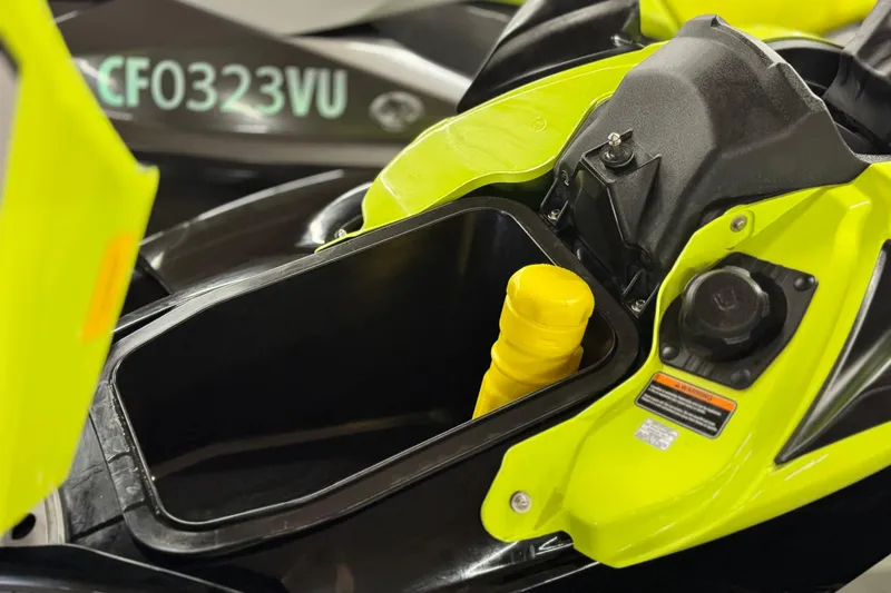 Slide: The Image of 2021 Kawasaki Jetski Ultra 310X storage compartment with yellow accessory, close-up view. - 10