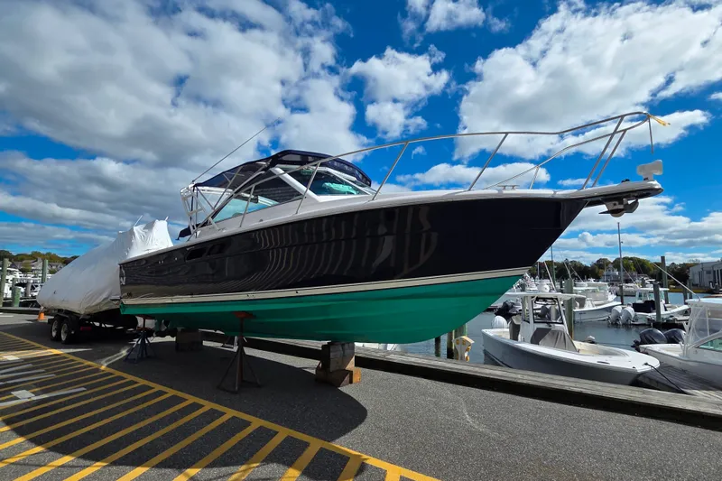 Slide: The Image of 2004 Tiara 29 Coronet Harbor Edition boat on trailer at marina under blue sky. - 4