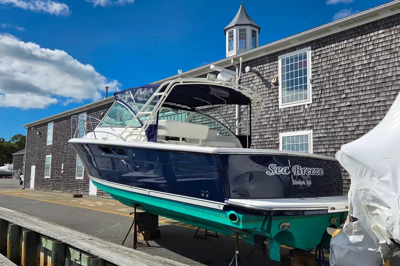 Slide: The Image of 2004 Tiara 29 Coronet Harbor Edition boat docked near a rustic building. - 5
