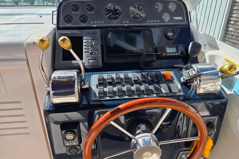 Slide: The Image of Control panel of a 2004 Tiara 29 Coronet Harbor Edition boat with wooden steering wheel. - 9