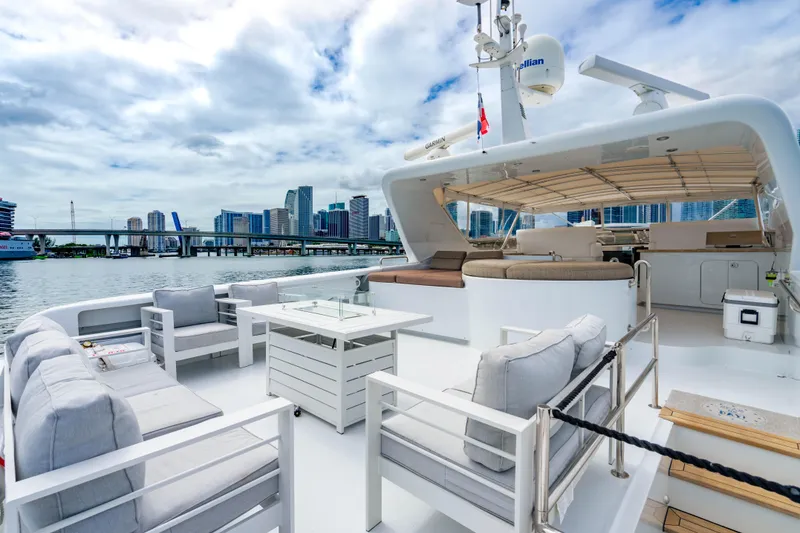 Slide: The Image of Luxurious 2000 Destiny Flybridge Motor Yacht with city skyline view, featuring elegant outdoor seating. - 21