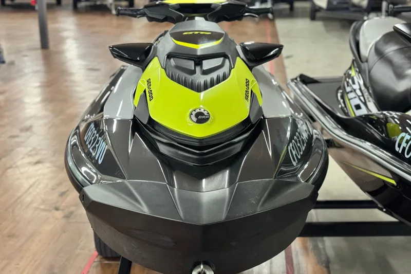 Slide: The Image of 2021 Sea-Doo GTR 230 jet ski in showroom, featuring sleek black and yellow design. - 1