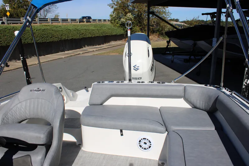 Slide: The Image of 2020 Stingray 192SC boat interior with gray seating and Suzuki 150 outboard motor. - 10