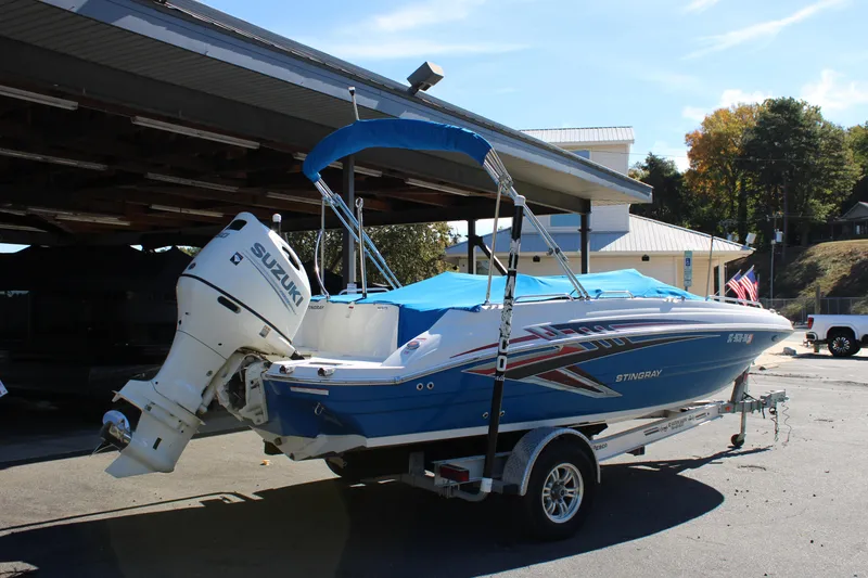 Slide: The Image of 2020 Stingray 192SC boat with Suzuki outboard motor on trailer, parked outdoors. - 24