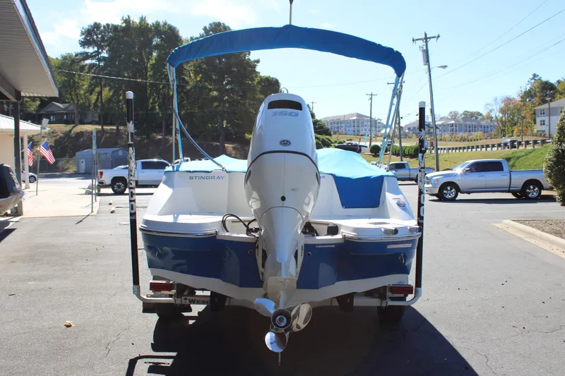 Slide: The Image of 2020 Stingray 192SC boat with blue cover and outboard motor in parking lot. - 26