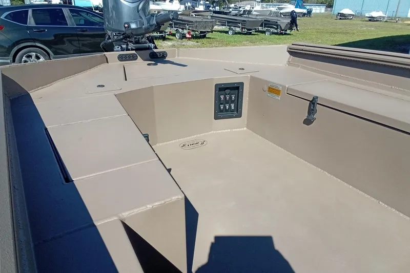 Slide: The Image of 2026 Thor 1754 Fish Hammer boat interior with control panel and motor, parked outdoors. - 10