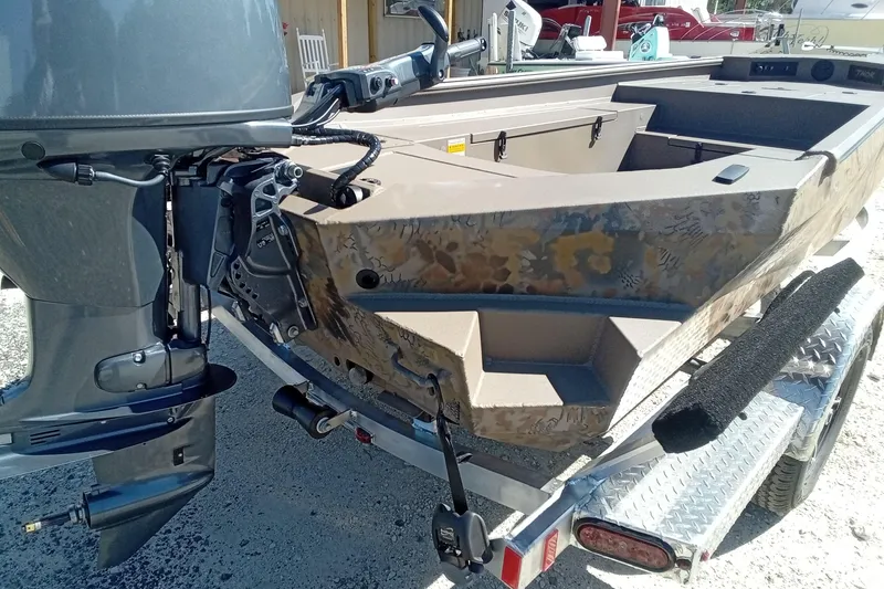 Slide: The Image of 2026 Thor 1754 Fish Hammer boat on trailer, featuring camouflage design and outboard motor. - 14