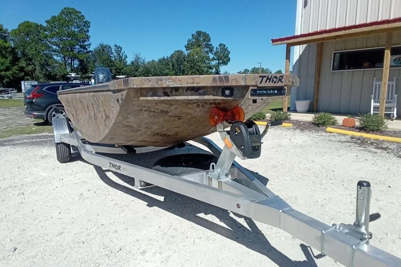 Slide: The Image of 2026 Thor 1754 Fish Hammer boat on trailer, parked outdoors near a building. - 4