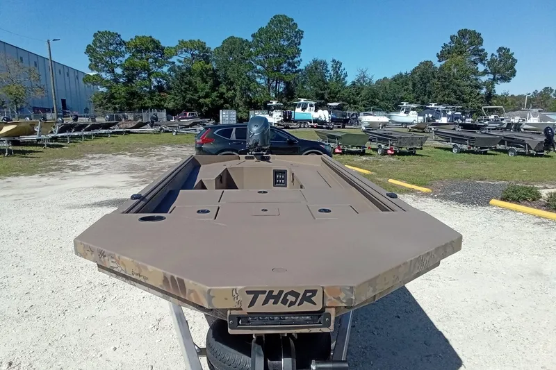 Slide: The Image of 2026 Thor 1754 Fish Hammer boat in outdoor showroom, surrounded by trees and other boats. - 5