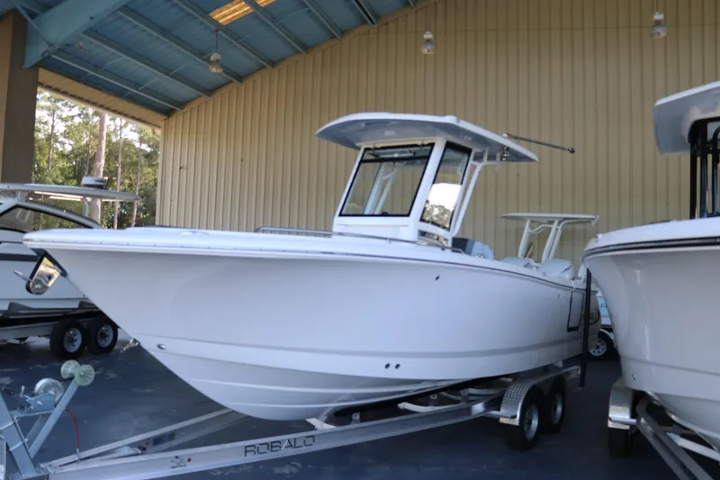 The Image of 2026 Robalo R250 Center Console boat on trailer in covered storage area. - 0