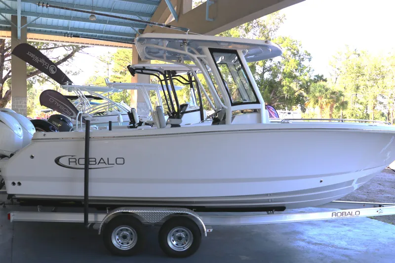 Slide: The Image of 2026 Robalo R250 Center Console boat on trailer in showroom. - 2