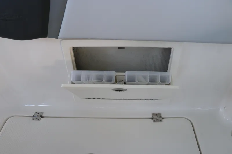 Slide: The Image of 2026 Robalo R250 Center Console storage compartment with organized tackle boxes. - 22