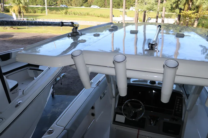 Slide: The Image of 2026 Robalo R250 Center Console boat interior with rod holders and steering console. - 28