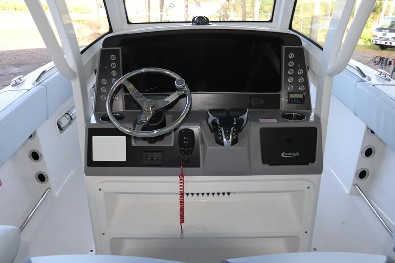 Slide: The Image of 2026 Robalo R250 Center Console boat dashboard with steering wheel and control panel. - 31