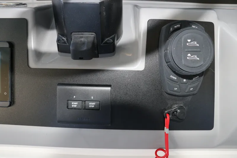 Slide: The Image of 2026 Robalo R250 Center Console boat controls with start/stop buttons and trim adjustments. - 34