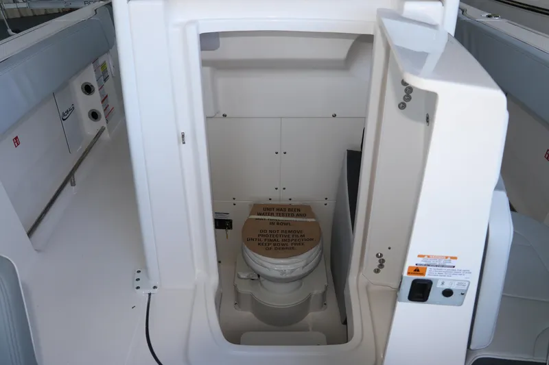 Slide: The Image of 2026 Robalo R250 Center Console boat interior with compact marine toilet. - 43