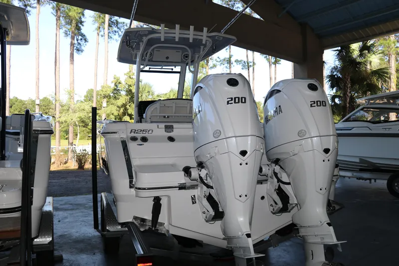 Slide: The Image of 2026 Robalo R250 Center Console boat with twin Yamaha 200 engines in a marina. - 5